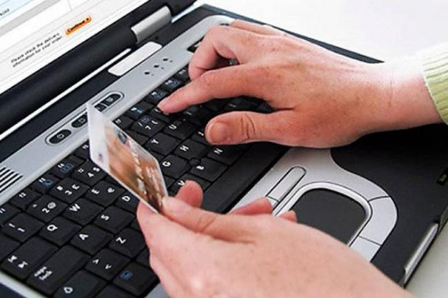 persona en el computador con una tarjeta de banco