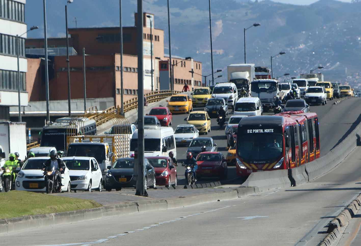 Gente que maneja por vías de uso exclusivo de Transmilenio
