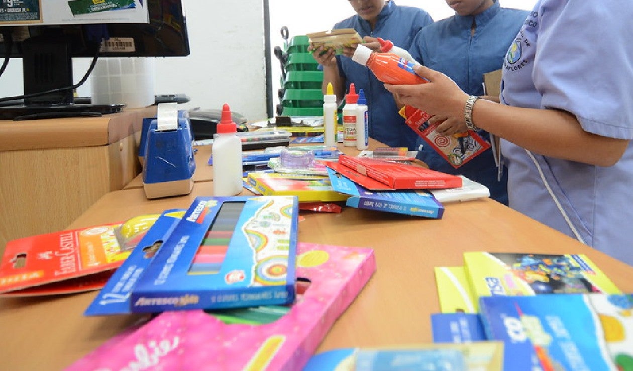 padres de familia comprando cuadernos