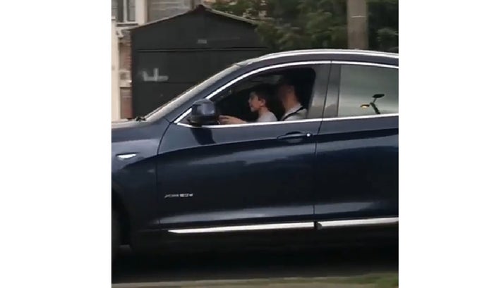 Niño manejando a alta velocidad en las piernas de un adulto