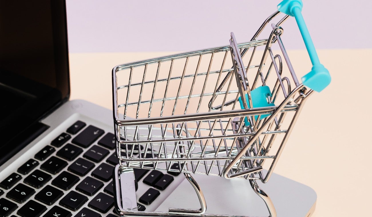 Carrito de compras junto a un computador
