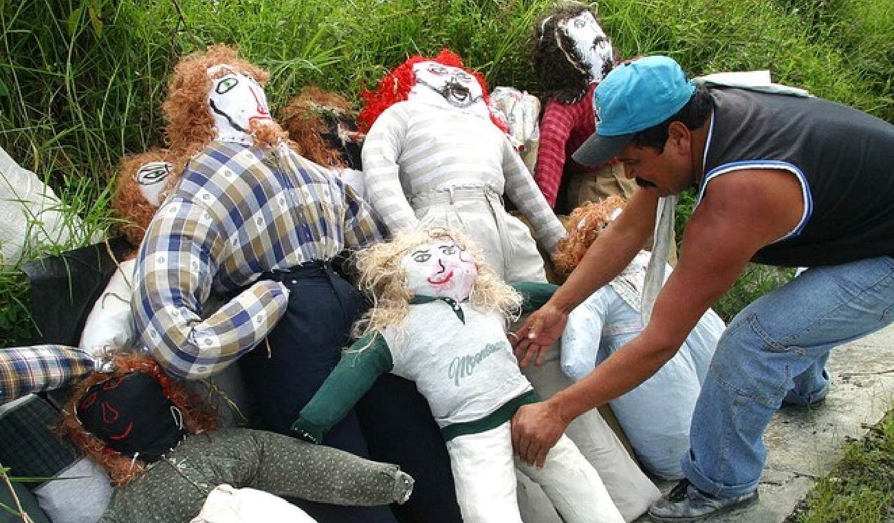 Hombre arruma distintos muñecos de trapo