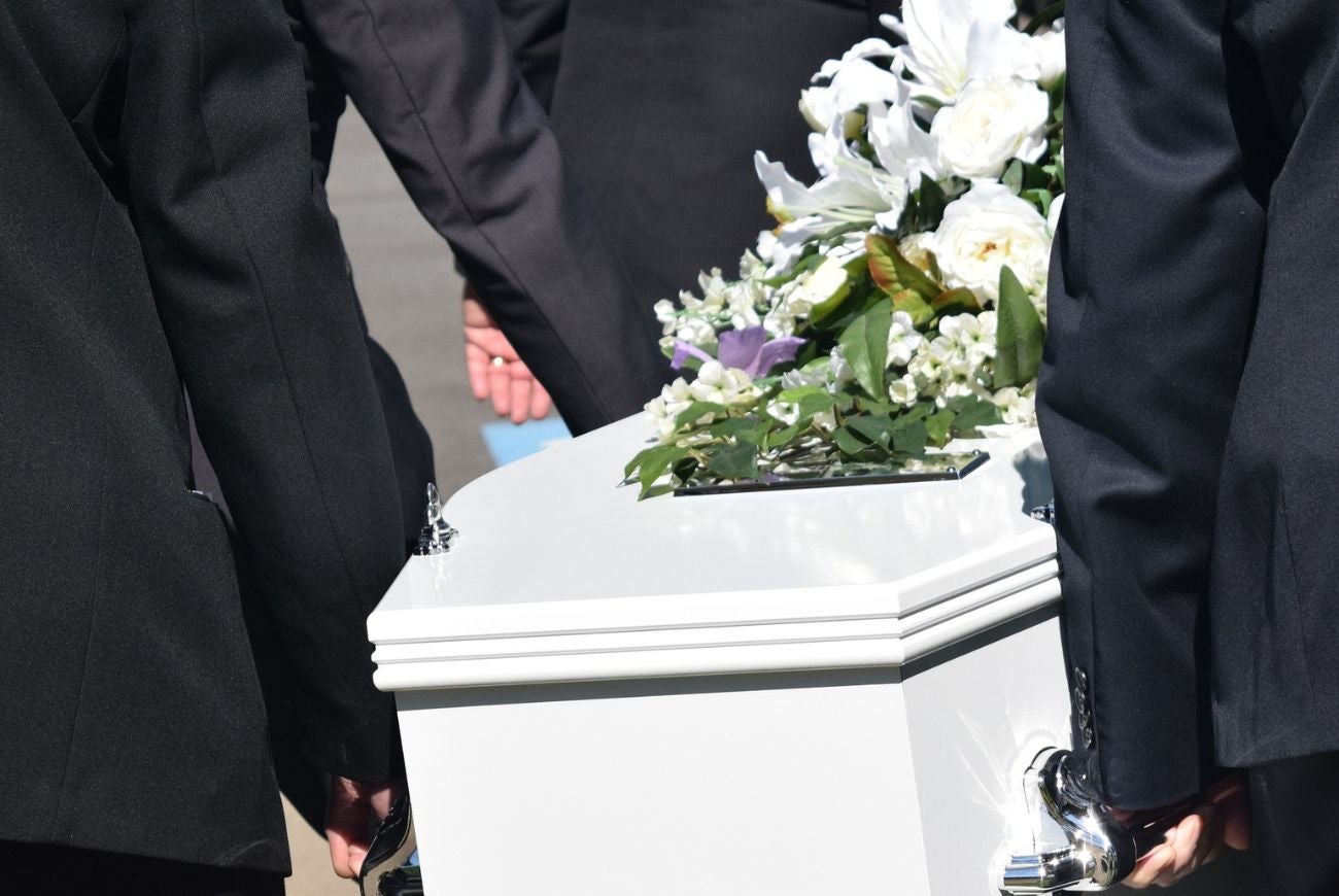 Hombres llevando un ataúd blanco