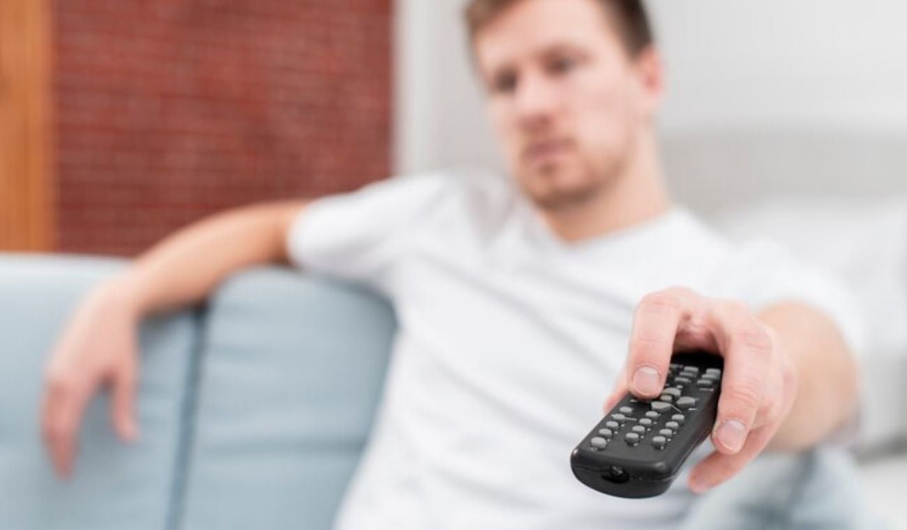 hombre usando el Control del televisor