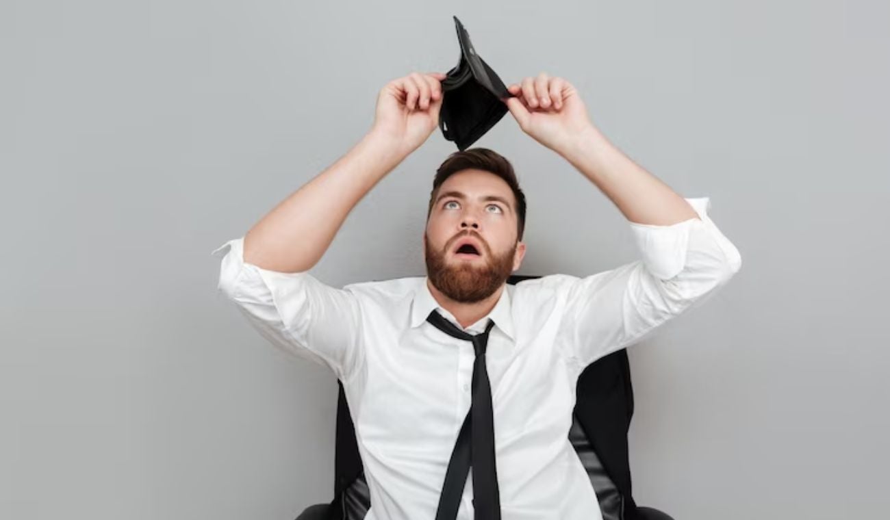 Hombre viendo que no tiene dinero en la billetera