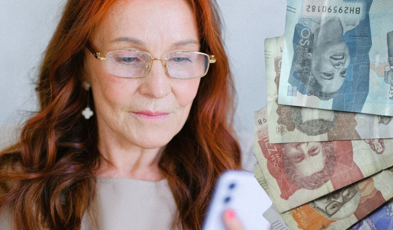 Mujer pensionada mirando el celular y dinero colombiano