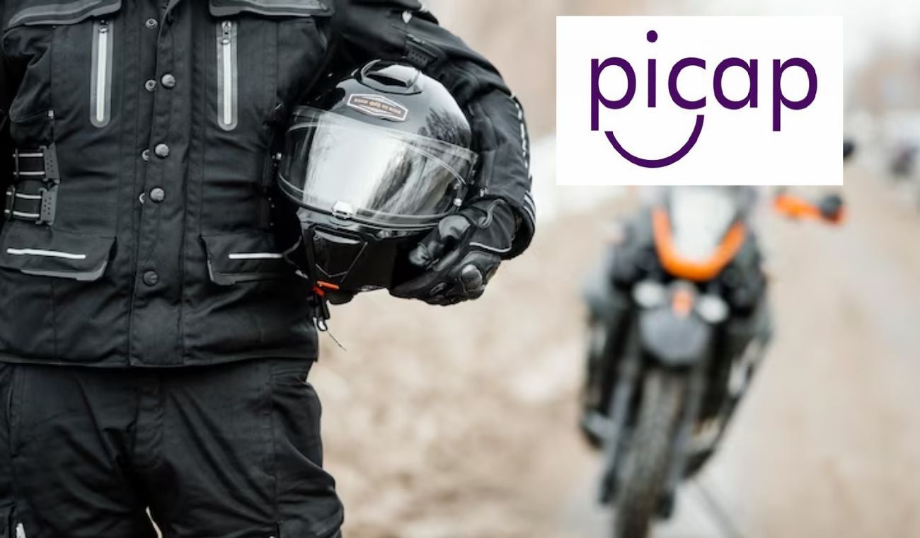 Motociclista sosteniendo un casco