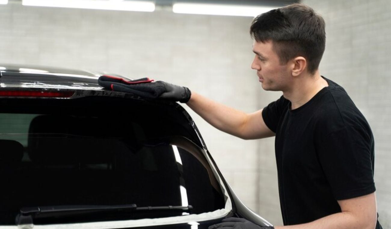 Persona aplicando vidrios polarizados en un carro