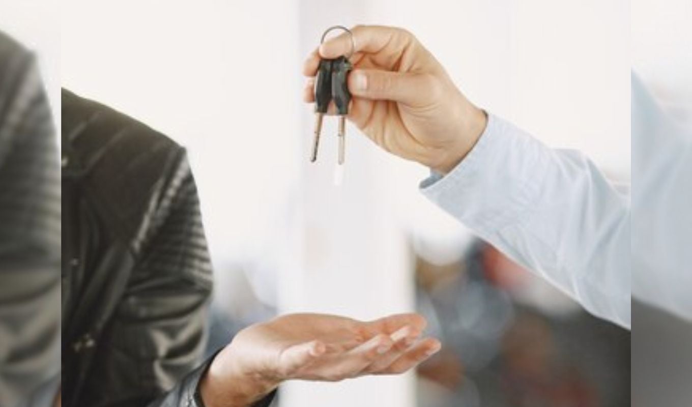 Persona entregando a otro las llaves de un carro