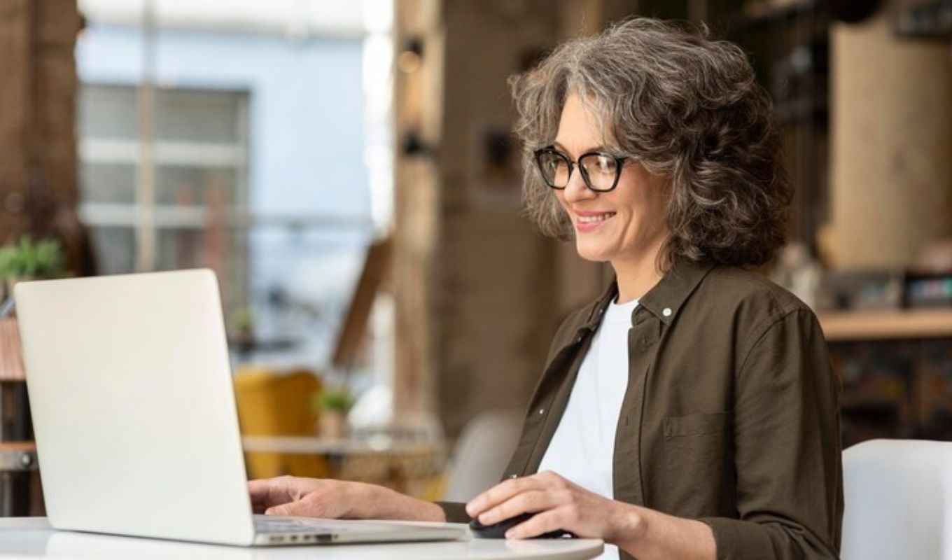 Mujer mayor haciendo trámites de pensión en el computador