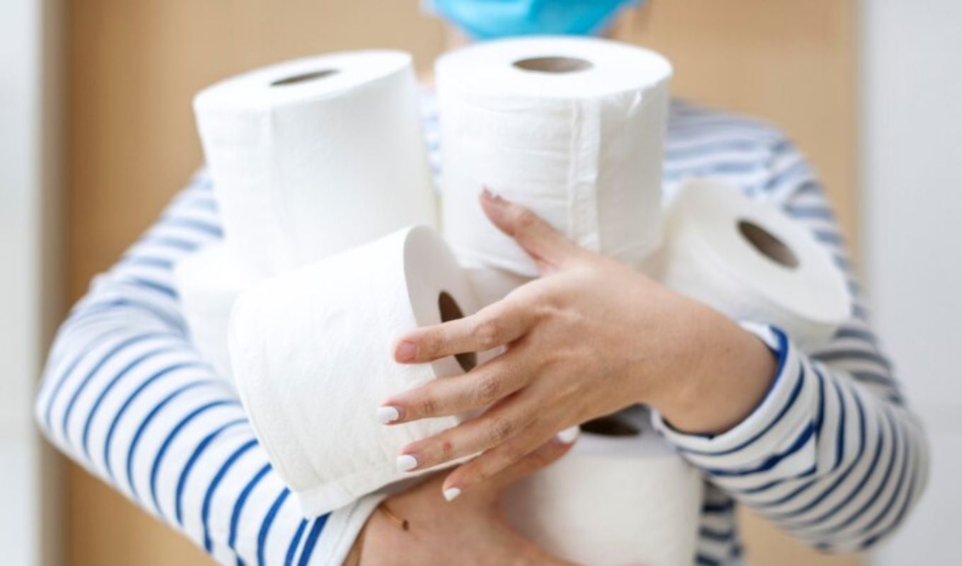 Mujer sosteniendo rollos de papel higiénico