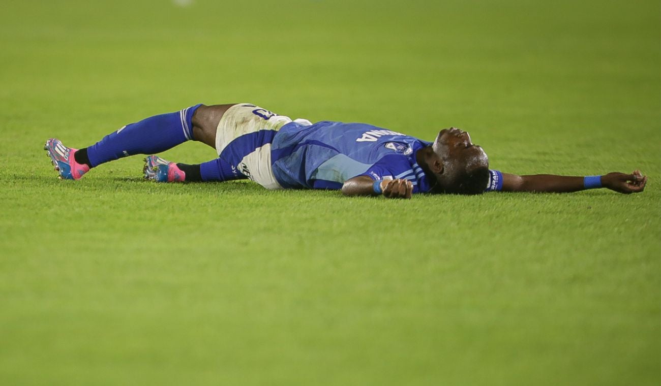 Jugador de Millonarios en el suelo en un partido.