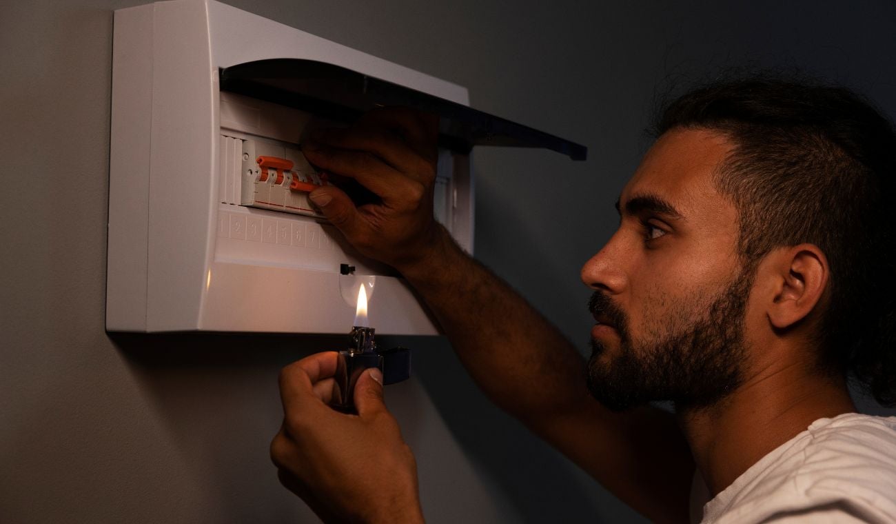 Hombre revisando la caja de energía de su vivienda