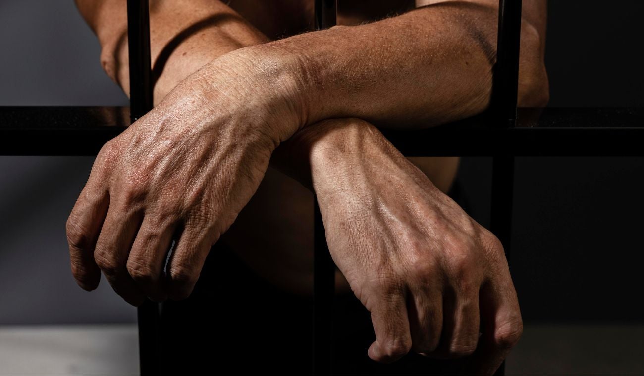 Hombre tras las rejas de una prisión