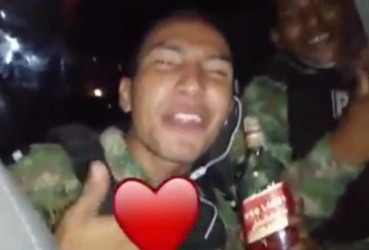 El uniformado enseñó en el video la botella de whisky.