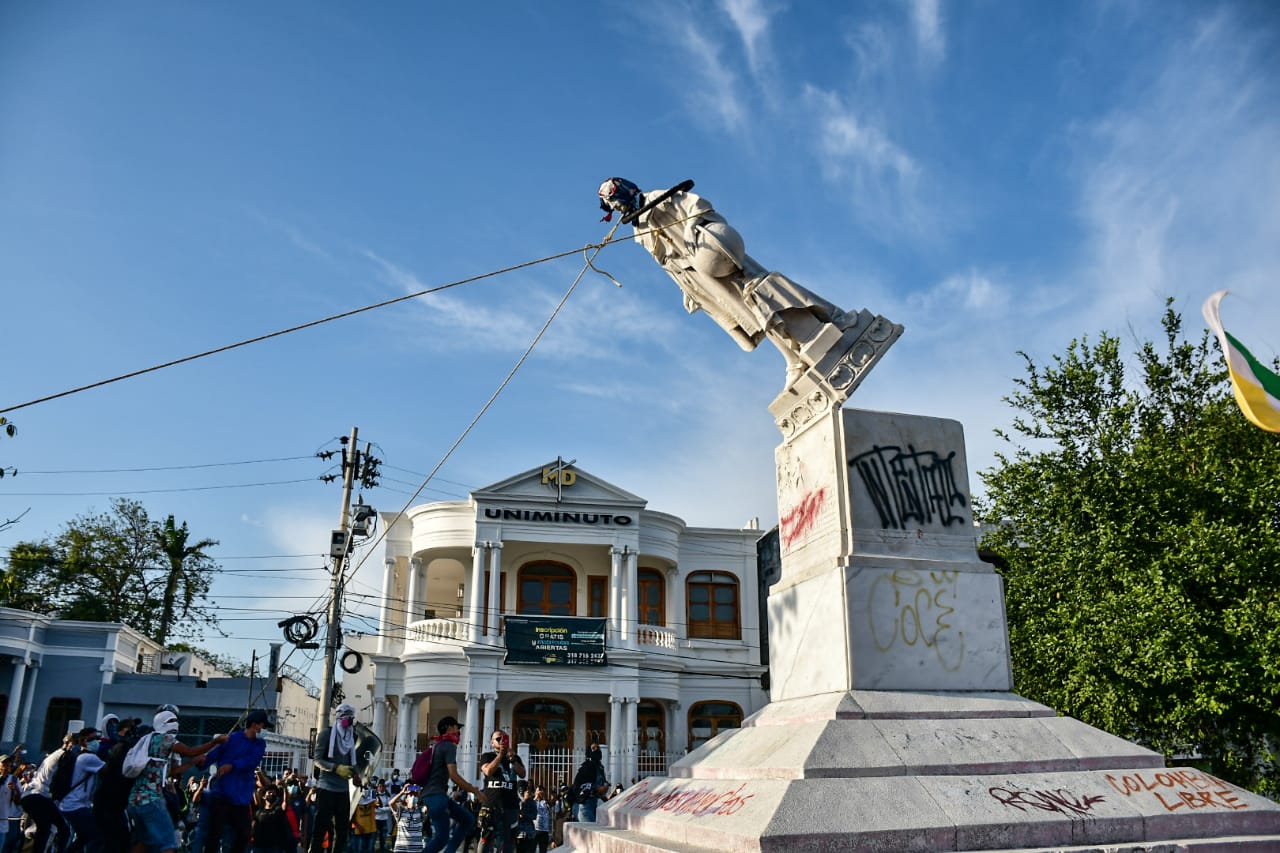 Manifestantes derriban estatua de Cristobal Colon.