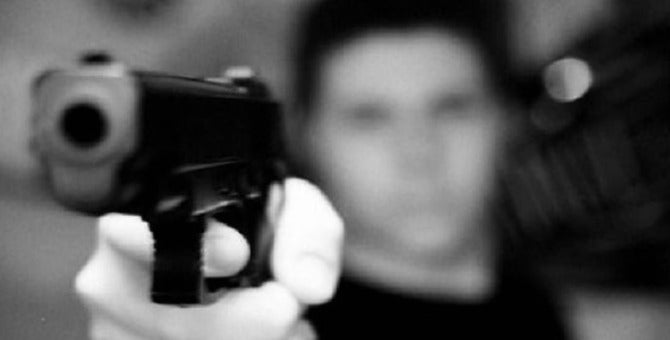 Hombre con un arma de fuego en las manos.