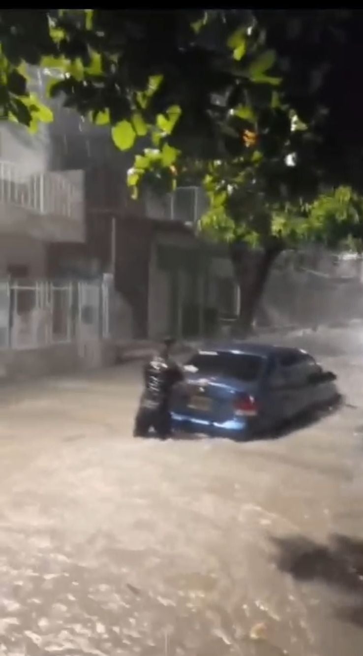 Carro atrapado pro lluvias mientras 2 personas lo empujan