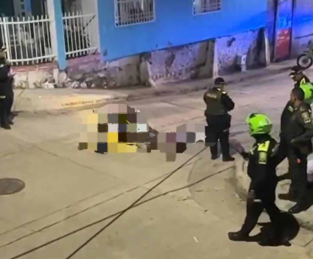 Hombres tendido en el piso y uniformados de la Policía en el lugar de los hechos