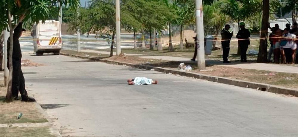 Persona muerta tendida en el piso.