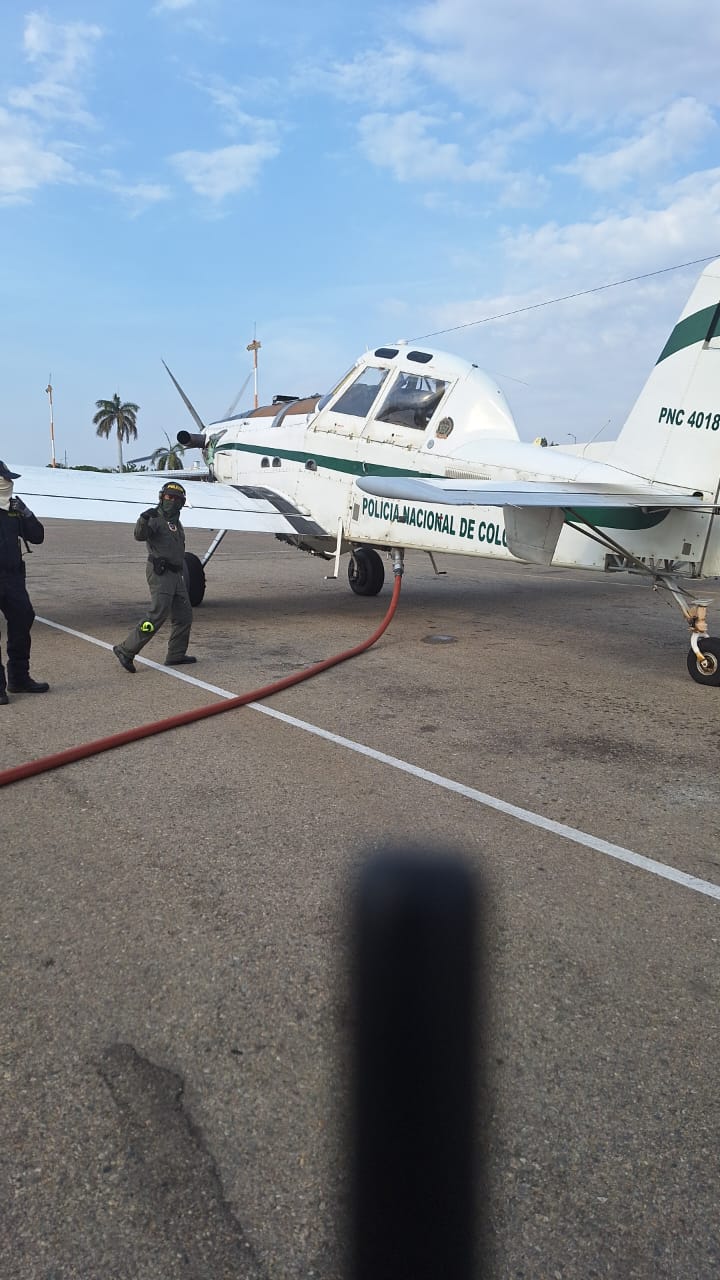 Un helicoptero y una avioneta de la policia desde el aire tratan de apagar las llamas