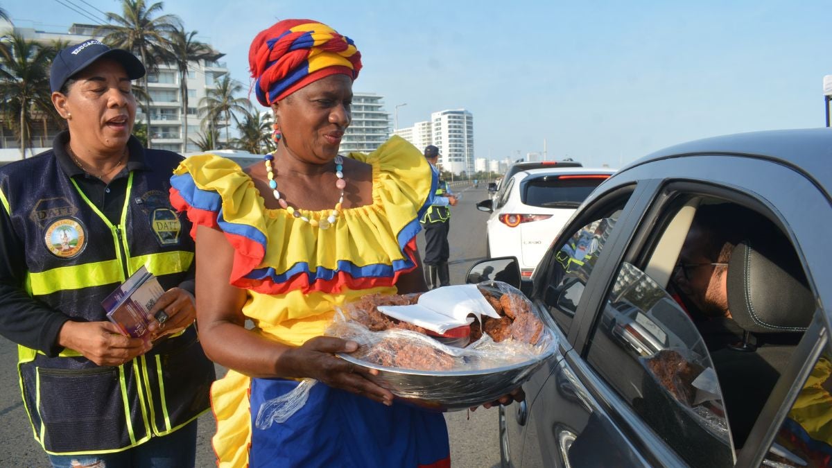 Imagen de palenqueras entregando dulces a los turistas
