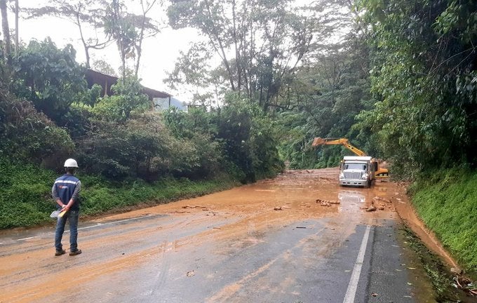 Con maquinaria amarilla tratan de remover los escombros que obstruyen la vía.