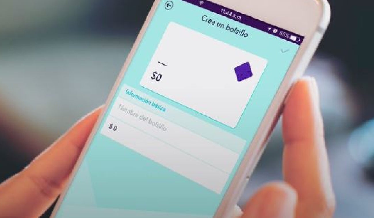 Persona sujeta teléfono celular con aplicación de Nequi abierta.