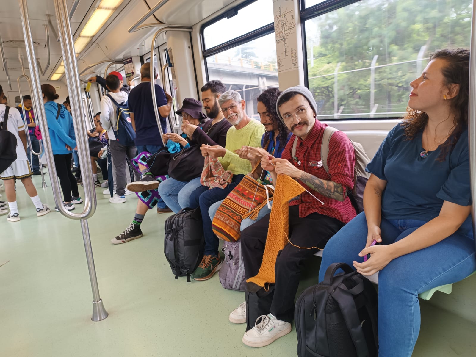 Hombres tejiendo en el Metro de Medellín