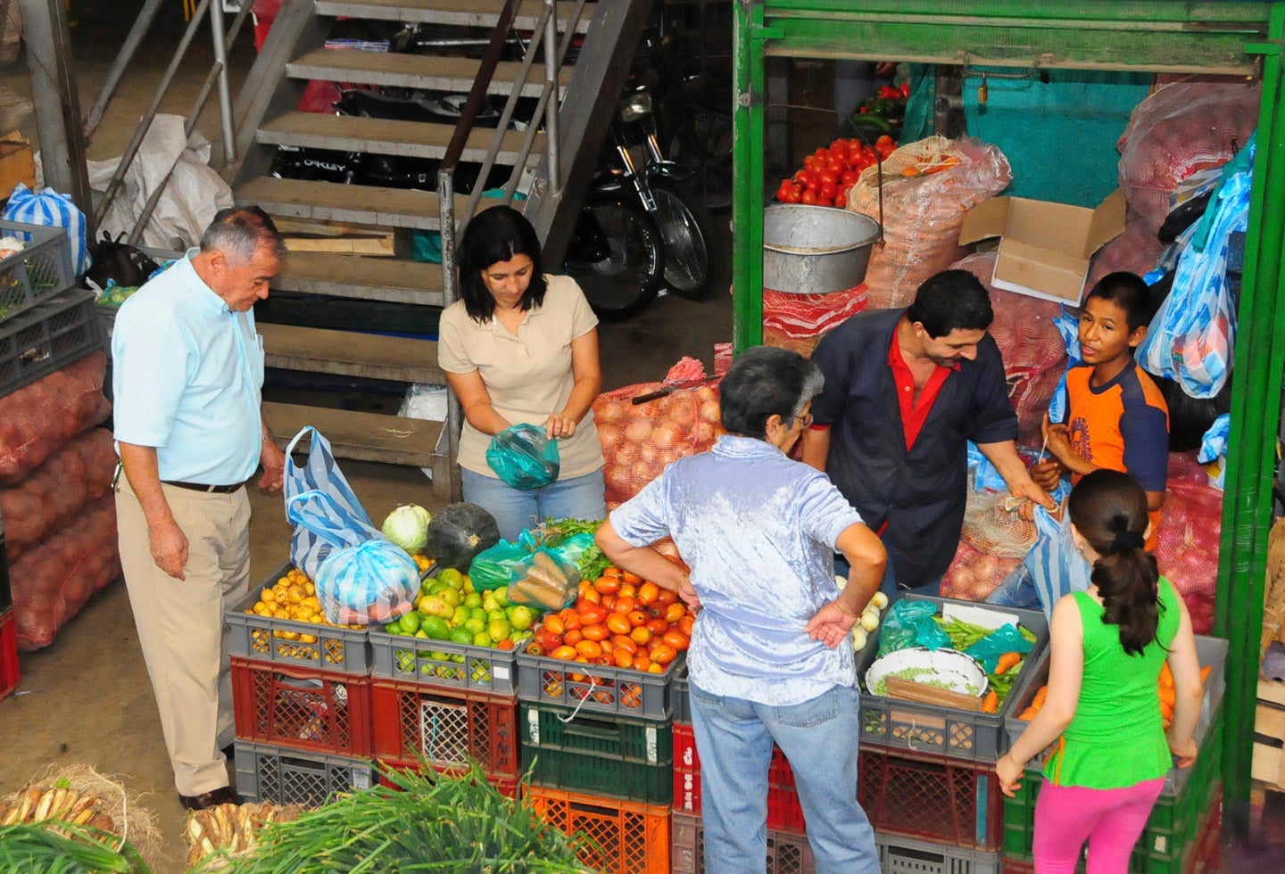 Consumidores en un mercado comprando productos básicos de la canasta familiar