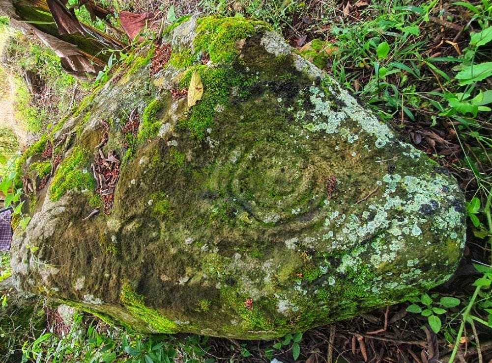 Piedra con petroglífos en formas en espiral y antropomorfas