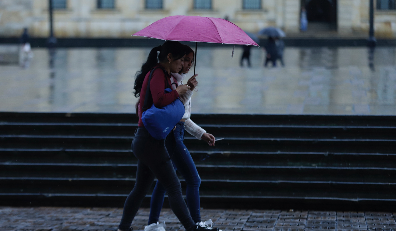 Personas caminando en época de lluvias en Bogotá