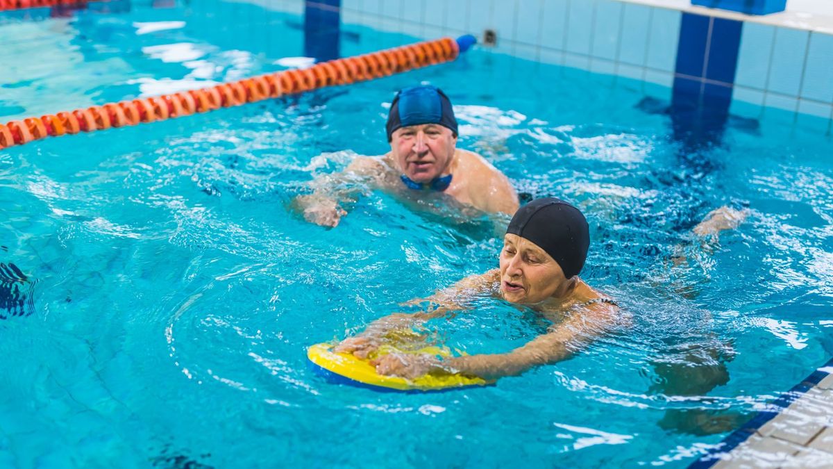 Dos personas aprendiendo a nadar en una piscina
