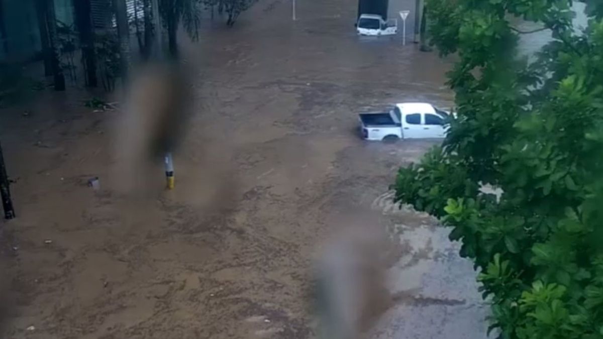 Carro hundido en calle inundada en Medellín