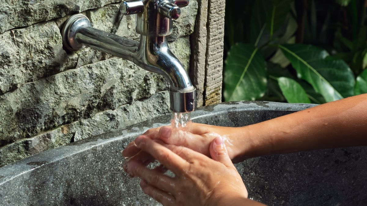 Persona lavándose las manos con agua