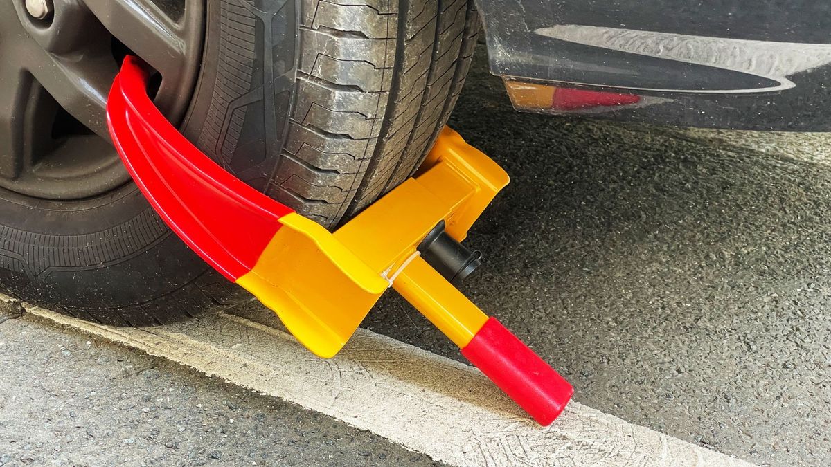 Cepo de llanta instalado para inmovilizar un carro