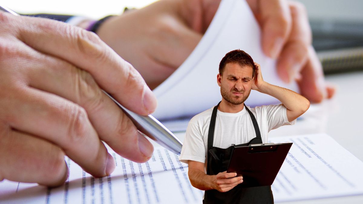 Comerciante leyendo un documento y de fondo mano firmando un papel