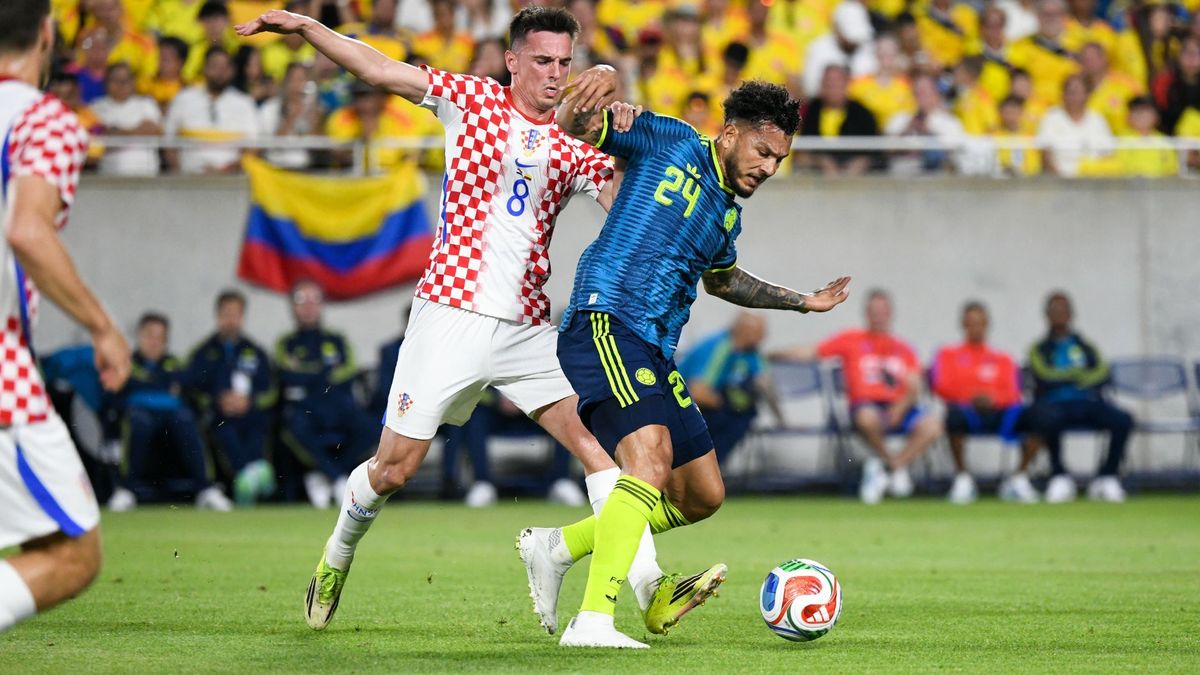 Luis Suárez disputando un balón contra un croata