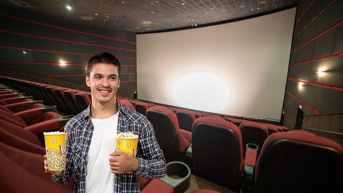 Hombre viendo película en sala de cine