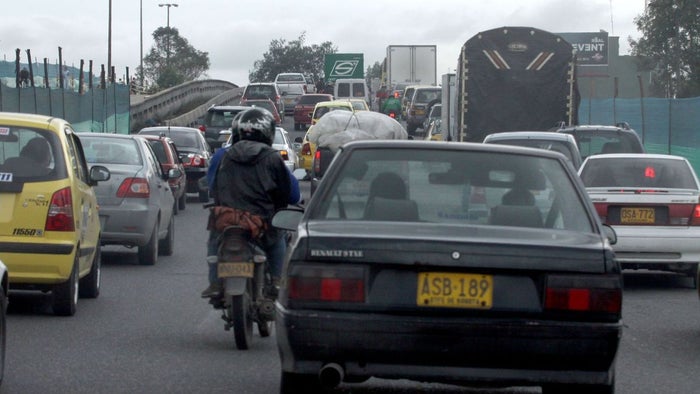 Carros y motos transitando en un trancón en Bogotá