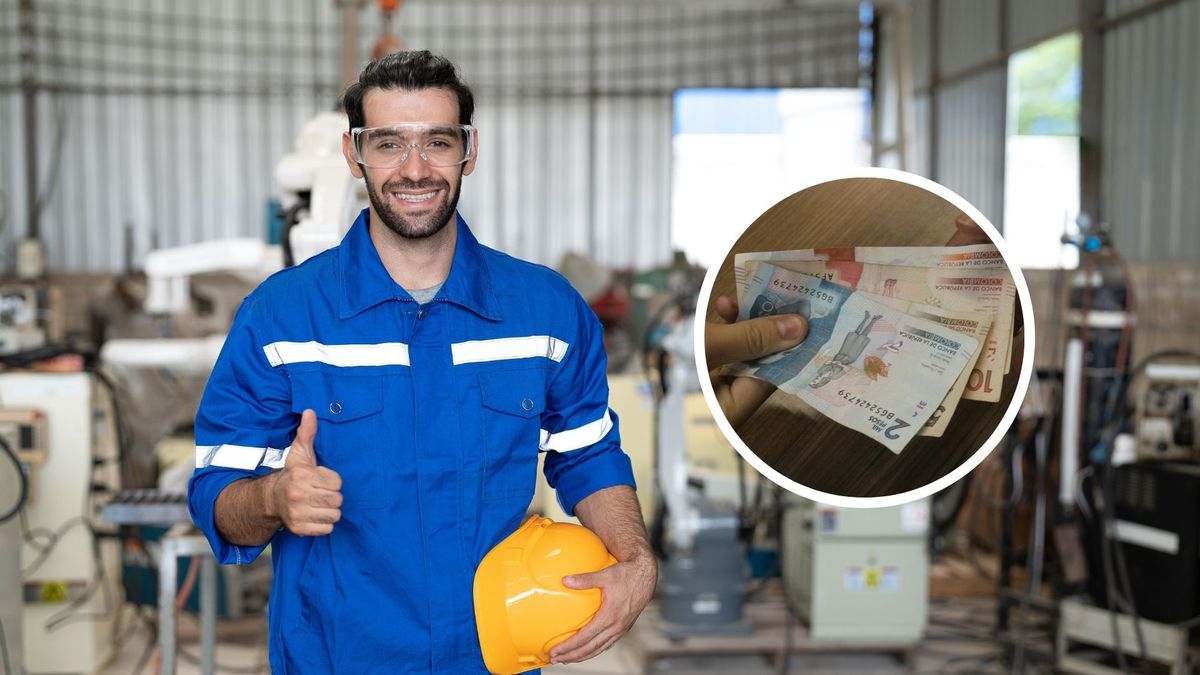 Trabajador con casco en el brazo y billetes colombianos