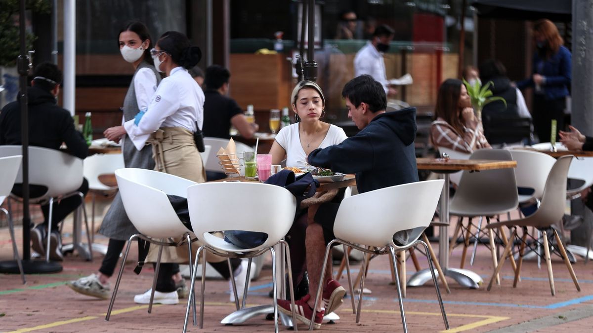 Personas almorzando en un sector de restaurantes al aire libre