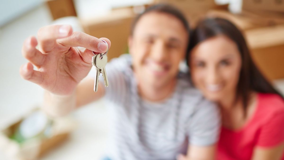 Pareja sosteniendo las llaves de su nueva vivienda