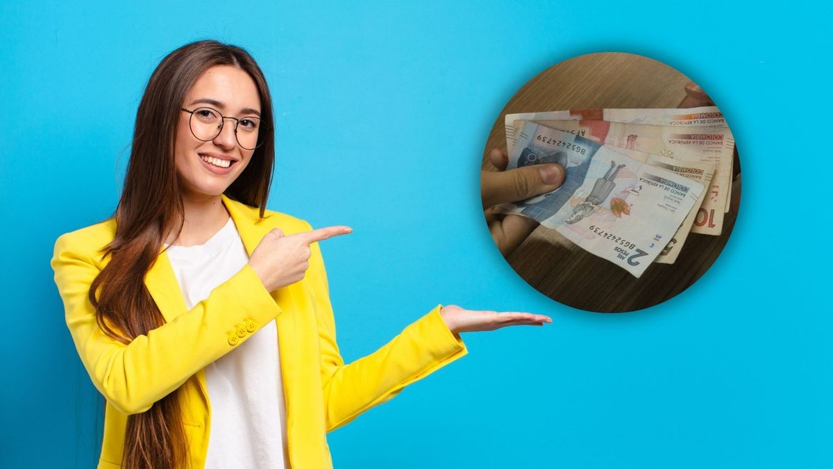 Mujer feliz señalando unos billetes colombianos