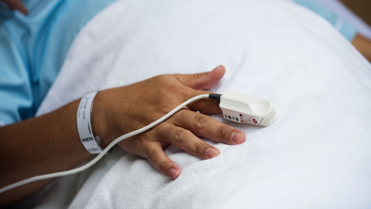 Persona canalizada y acostada en una camilla de UCI