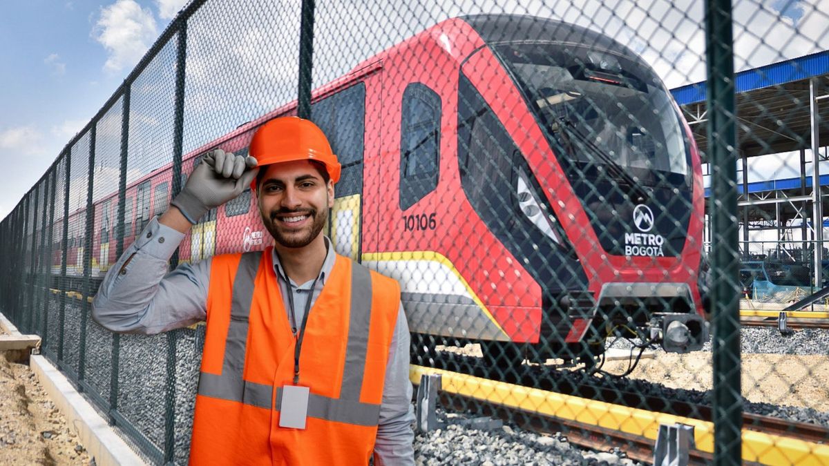 Trabajador y de fondo un tren del Metro de Bogotá.