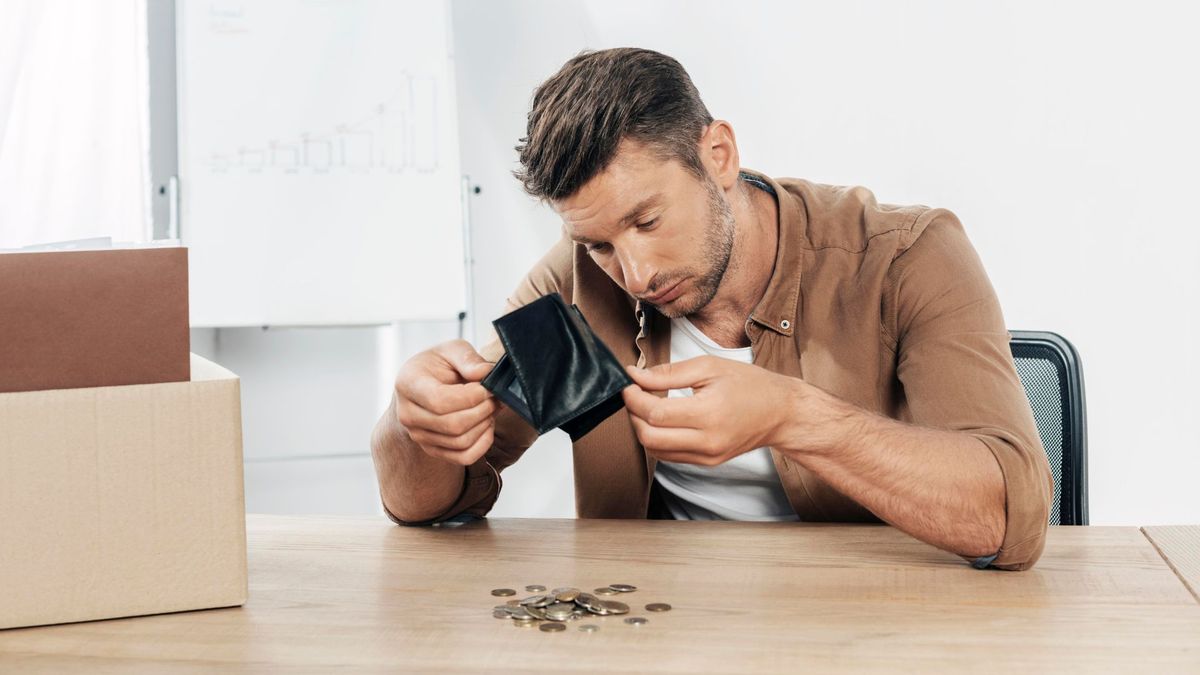 Hombre vaciando monedas de su billetera