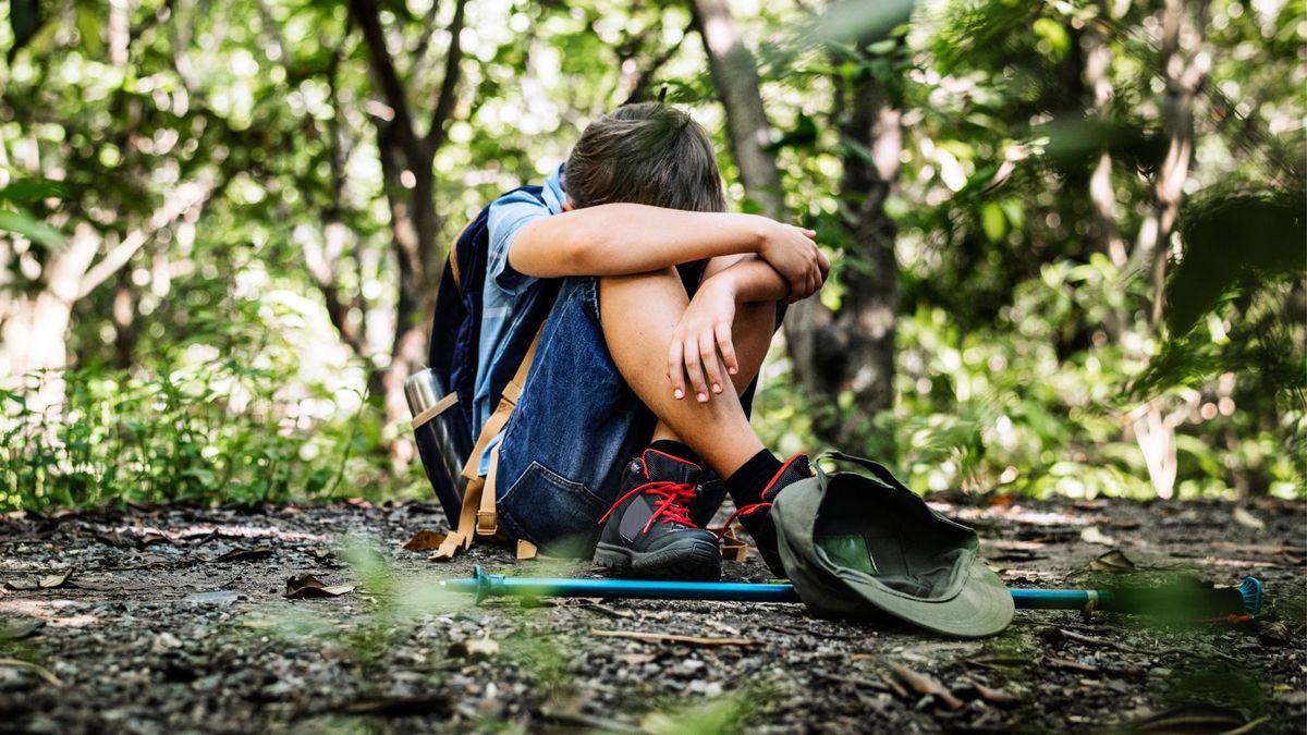 Menor sentado y perdido en un bosque