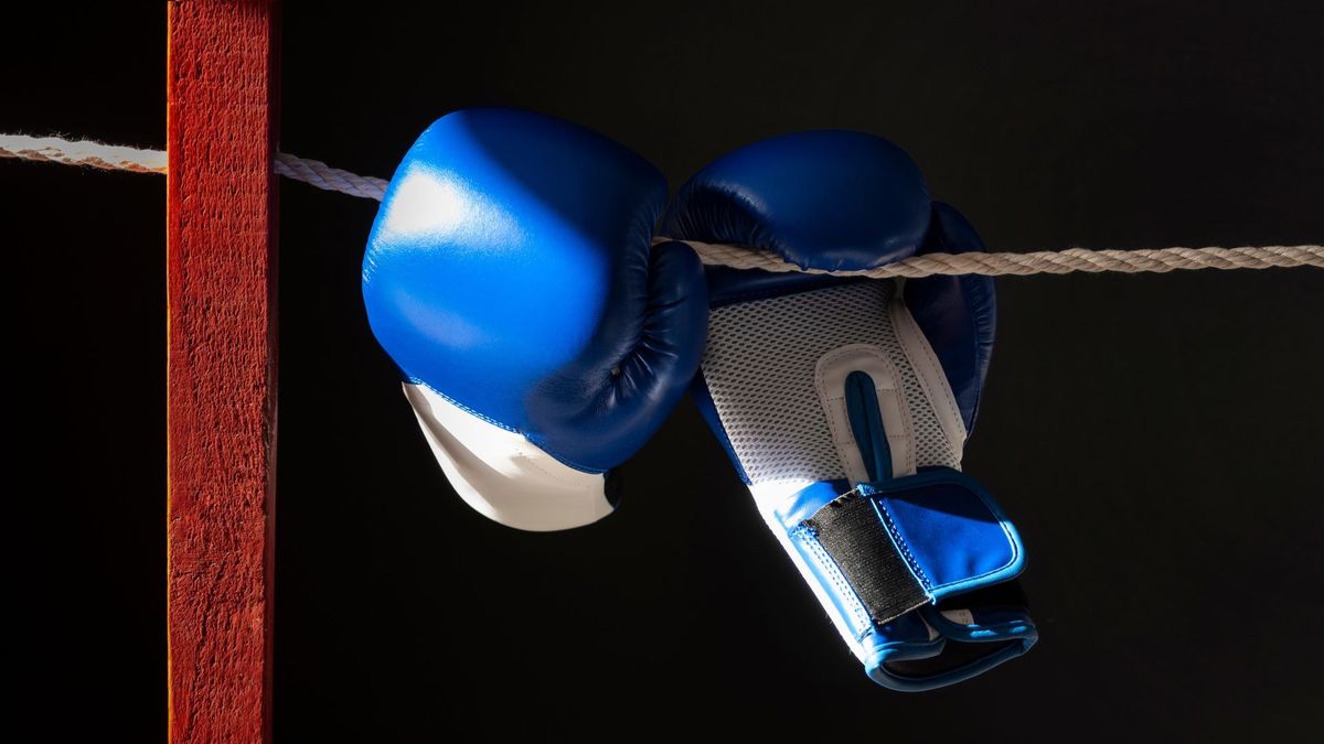Guantes de boxeo colgados sobre la lona