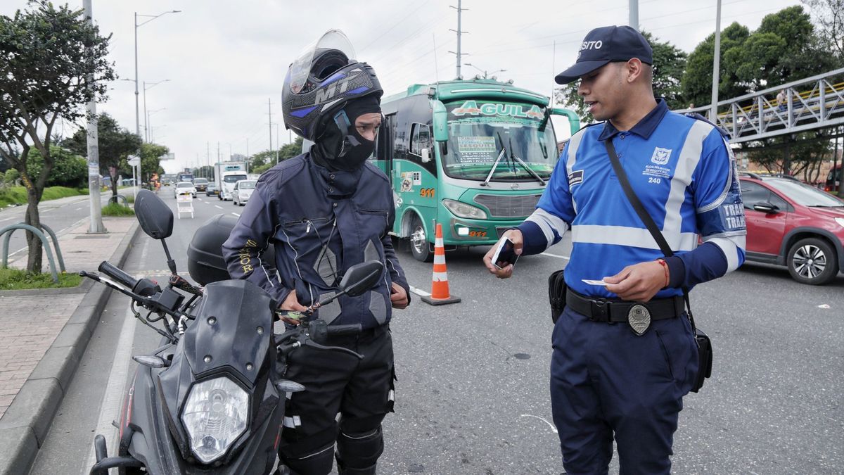 Policía de Tránsito hablando con un motociclista en un puesto de control
